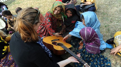 Sarah Adeel with acoustic guitar and group of Pakistani girls