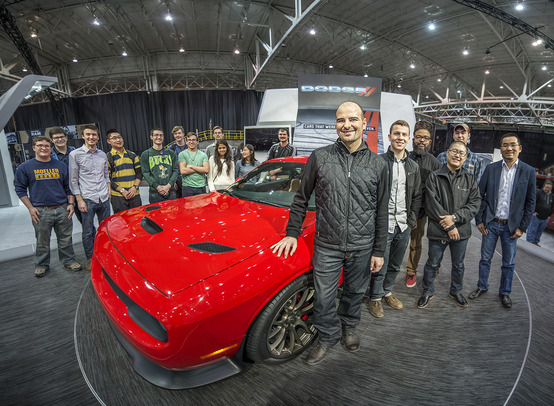 Photo of Nicho Vardis with students and car