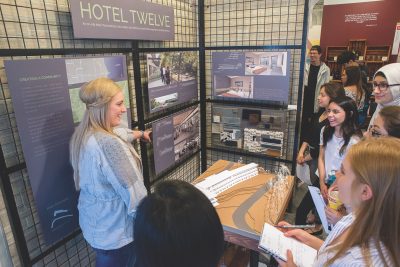 Teacher discussing architecture model with students