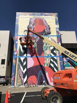 Photo of Patrick Miller painting the mural