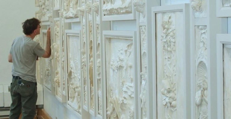 Artist working on an ornate wall restoration