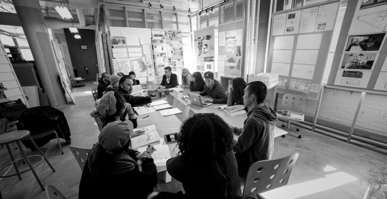 Group of students and teachers around a long table