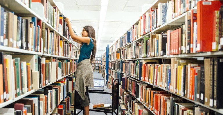 Student in library stacks