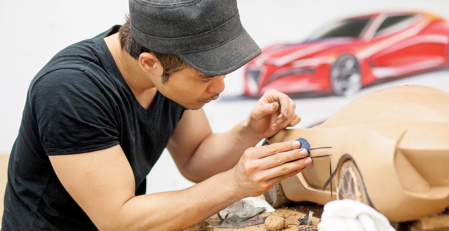 Student modeling a car in clay