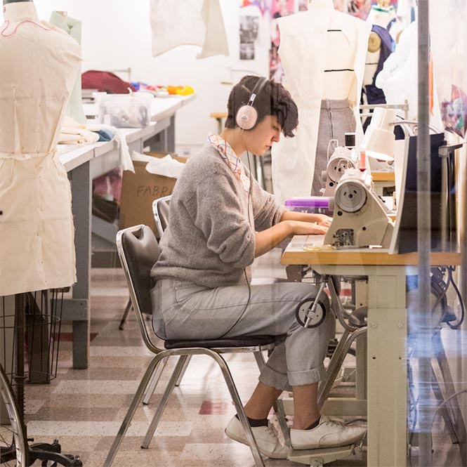 Fashion design student working in studio at a sewing machine