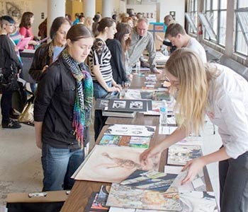 Students at tables during Portfolio Day